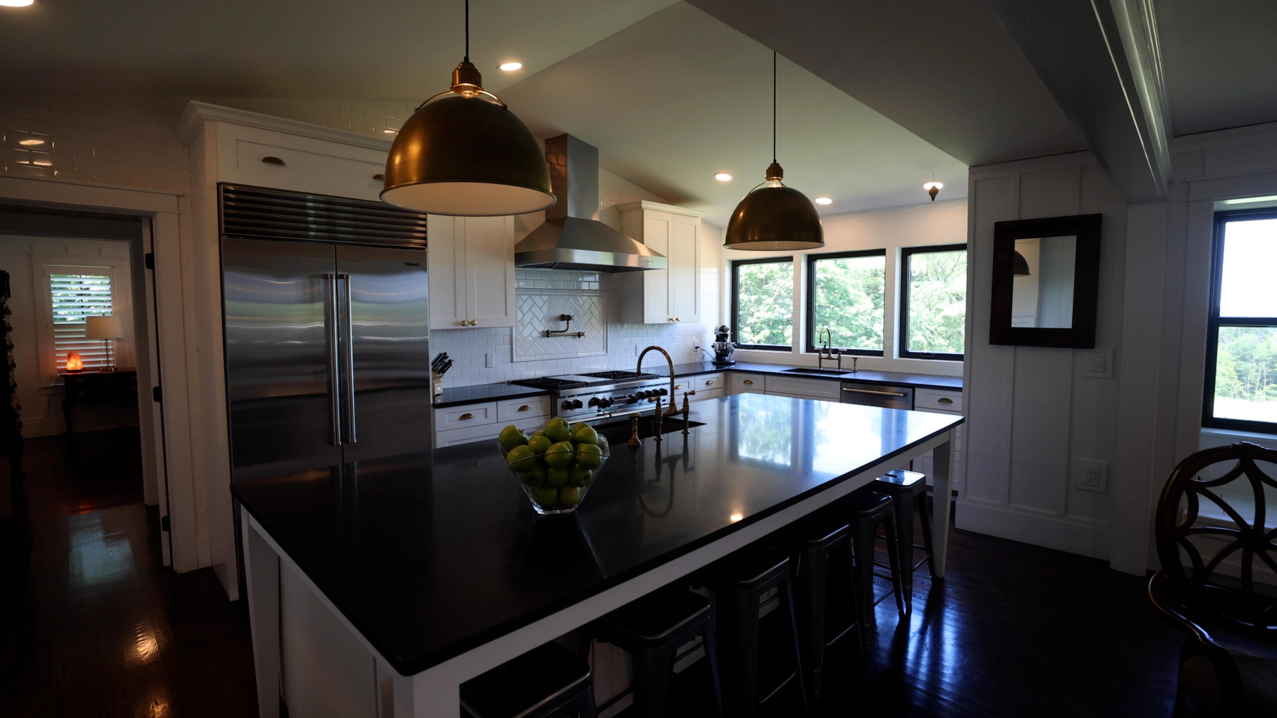 White chef's kitchen with large island and professional appliances